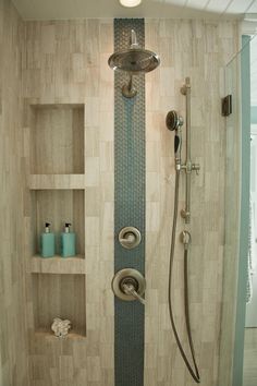 the shower head is mounted on the wall above the toilet and shelves in the bathroom