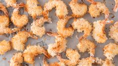 fried shrimp on a sheet of parchment paper with crumbs all over the surface