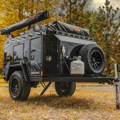 an off - road vehicle parked on the side of a road in front of some trees