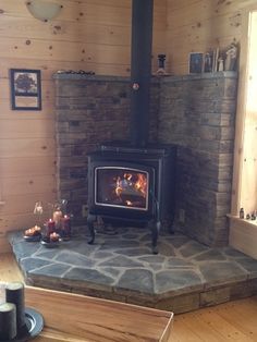 a wood burning stove sitting inside of a living room next to a wooden flooring area