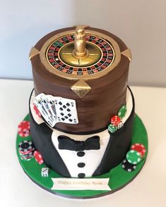 a casino themed birthday cake with a rouleet and playing cards on the top