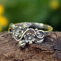 A leafy vine with blushing daisies brings this whimsical design by Wadarat Supasirisuk to life. Show off this fair trade sterling silver ring with any outfit. Sterling silver Combination finish Handmade in & fairly traded from Thailand Rose Cocktail, Silver Flower Ring, Sterling Silver Rings Bands, Dope Jewelry, Funky Jewelry, 판타지 아트, Sterling Silver Flowers, Silver Band Ring, Jewelry Inspo