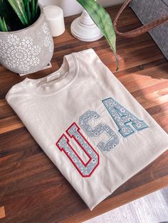 a white t - shirt with the number 46 on it next to a potted plant