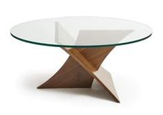 a glass and wood table with an x design on the top, in front of a white background