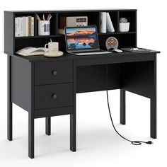 a computer desk with a laptop on top of it next to a book shelf and other items