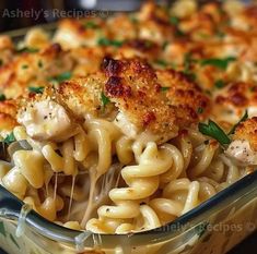 macaroni and cheese with chicken is being lifted from the casserole dish