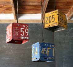 three different colored boxes hanging from the ceiling with numbers painted on them and number tags attached to each box