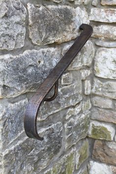 a metal hook on the side of a stone wall