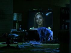 a woman is sitting on the floor in front of a television with her head down