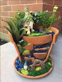 a potted planter filled with lots of plants and small gnome figurines