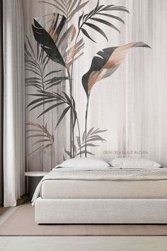 a white bed sitting in front of a wall with leaves on it and a plant mural behind it