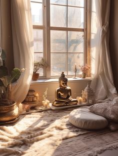 a buddha statue sitting on top of a bed next to a window