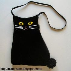 a black cat purse with yellow eyes on it's face and a strap around its neck