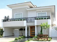 a white two story house with balconies on the second floor