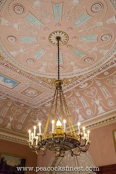 a chandelier hanging from the ceiling in a room with pink walls and ceilings