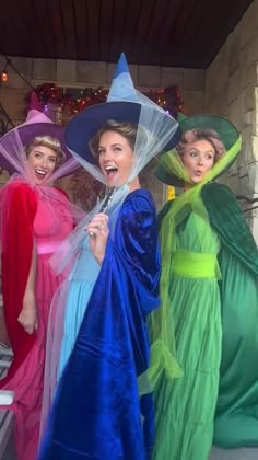 three women dressed in costumes and hats posing for the camera