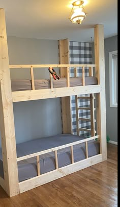 a bunk bed with two sets of mattresses on top of it in a room