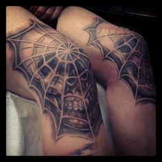 two men with tattoos on their arms and legs, one is covered in spider webs