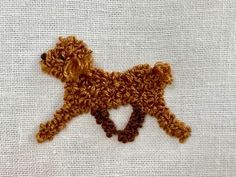 a brown dog with a heart on it's back made out of crochet