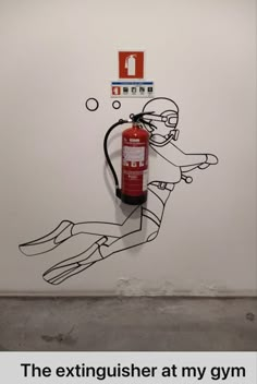 a red fire extinguisher sitting in front of a white wall with graffiti on it