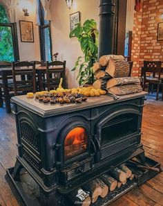 an old fashioned wood stove with logs stacked on top