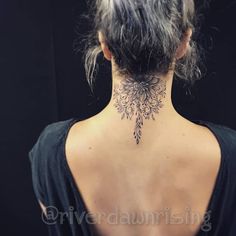 the back of a woman's neck is covered with tattoos