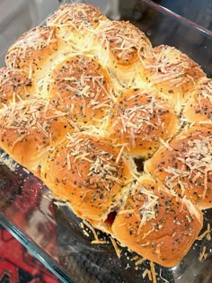 a hot dog bun covered in cheese and sprinkled with shredded parmesan