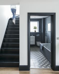 an open door leading to a bathroom with black and white tiles