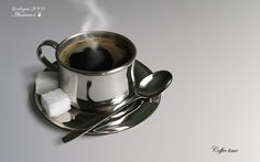 a cup of coffee and spoon on a saucer with sugar cubes next to it