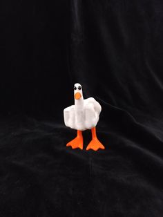 a white duck with an orange beak on a black background