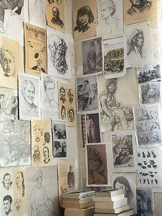 wall of art Art sketches and drawings cover a wall above stacked books, featuring faces, figures, and historical scenes. | Sky Rye Design