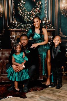 a family posing for a photo in front of a christmas tree