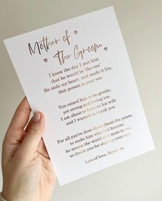 a person holding up a card with the words mother of the groom written on it