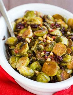 a white bowl filled with brussel sprouts on top of a red cloth