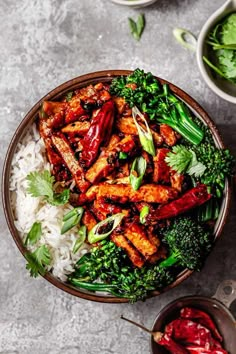 a bowl filled with chicken and broccoli on top of rice next to bowls of sauce