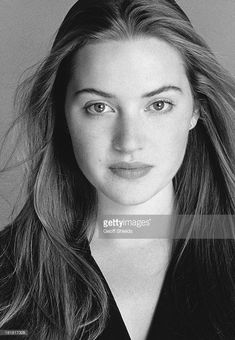 a black and white photo of a woman with long hair, looking at the camera