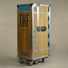 a wooden and metal container with the word thf on it's side, sitting in front of a gray background