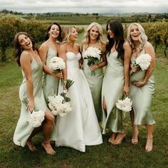 a group of women standing next to each other on top of a lush green field