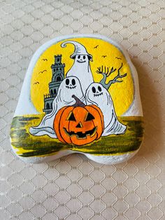 a painted rock with two ghostes and a castle on it