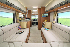 the inside of an rv with couches and windows