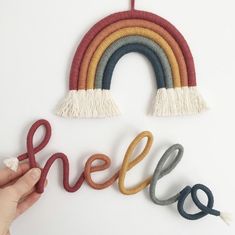 someone is holding the word hello spelled out with yarn