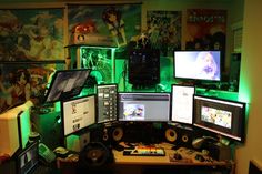 there are many computer screens on the desk in front of each other, all lit up with green lights