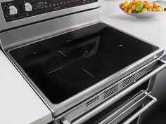 a bowl of fruit is sitting on the counter top next to an oven and stove