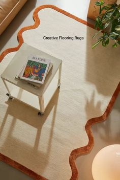 a table with a book on top of it next to a plant and a candle