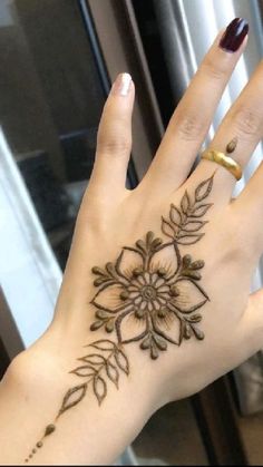 a woman's hand with a flower tattoo on it