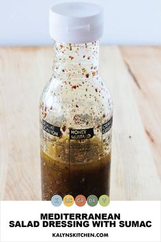 a bottle filled with brown liquid sitting on top of a wooden table