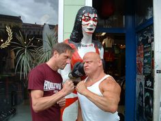 two men standing next to each other in front of a statue