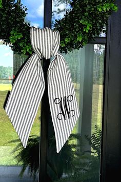 a black and white striped wreath with monogrammed ribbon hanging on the front door