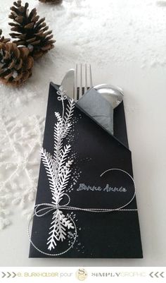 a place setting with silverware and napkins on top of snow - covered ground