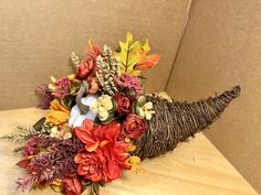 an arrangement of flowers and leaves on a table